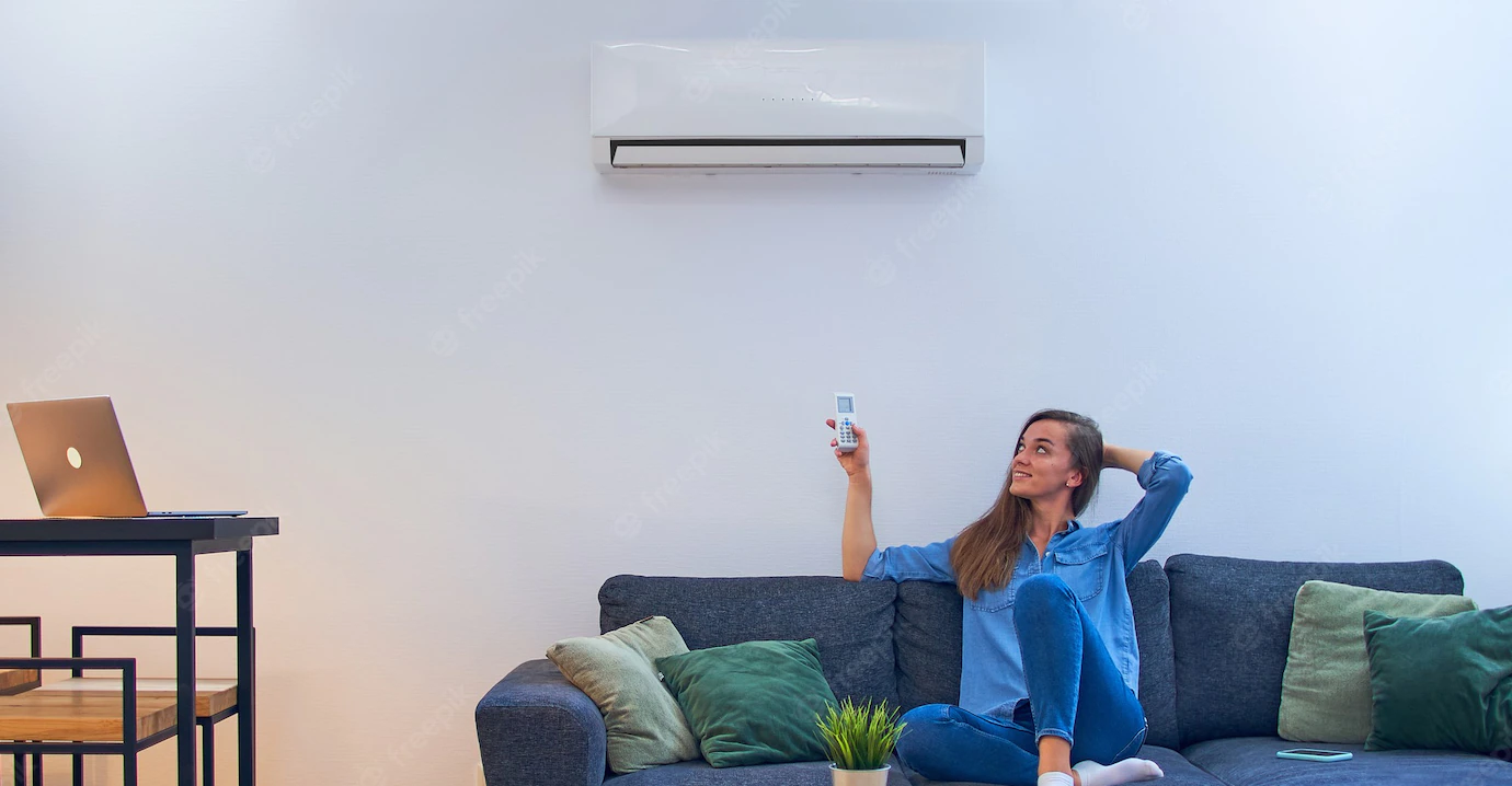 Schneider Electric Soldes 10 Schneider Electric Soldes -Schneider Electric Soldes young happy woman sitting couch air conditioner adjusting comfort temperature with remote control modern home 122732 3722